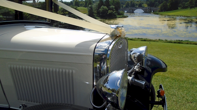 front part of the vintage car showing the chrime grill and large chrome mounted headlights