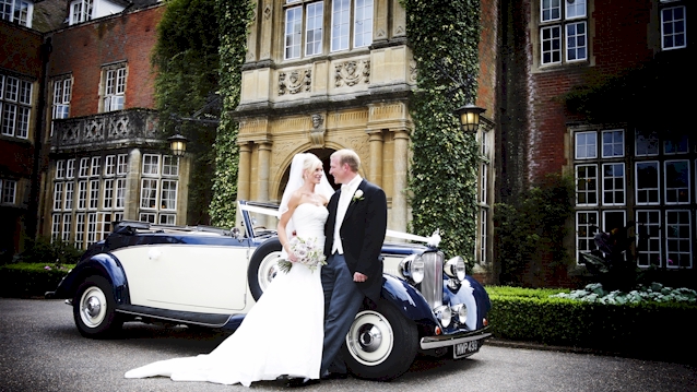 Vintage Royale Car in front of venue with bride and grooom next to the vehicle