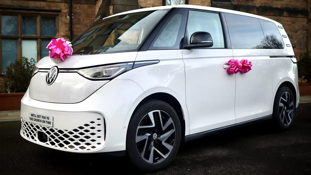 White Electric VW ID Buzz  decorated with Pink bows on the front of the car and door handles