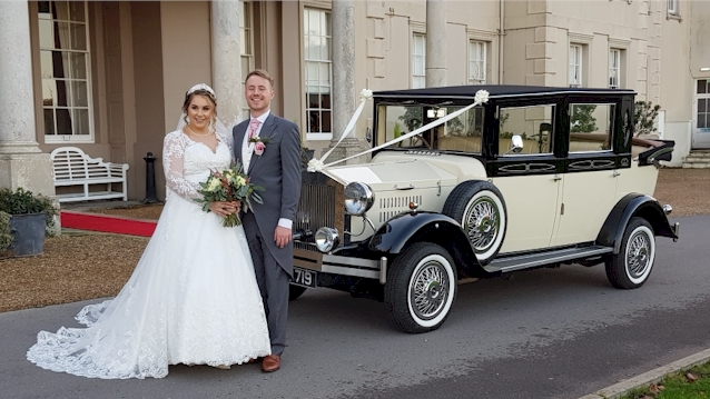 Bride and Groom standing in front of a Black & Ivory vintage car