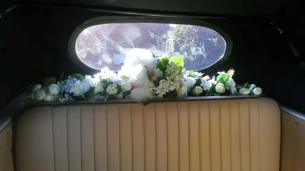 inside rear bench seat in cream with artificial white flowers and green foliage on parcel shelf