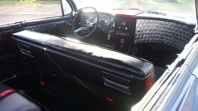 interior view of a Classic Cadillac showing black leather interior and large seating area