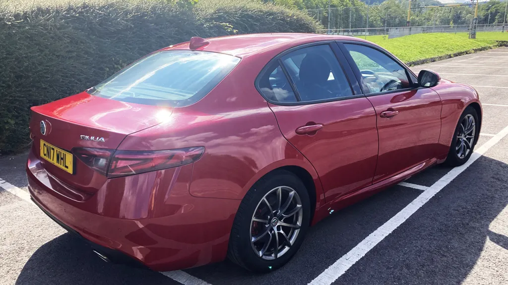 Rear side view of Alfa Romeo Giulia in Red with black and silver wheel arches