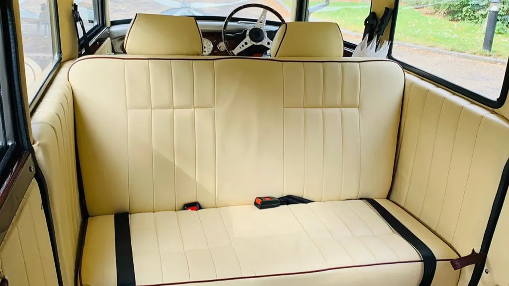 Rear interior of one of the cream leather bench seat showing the seat belts