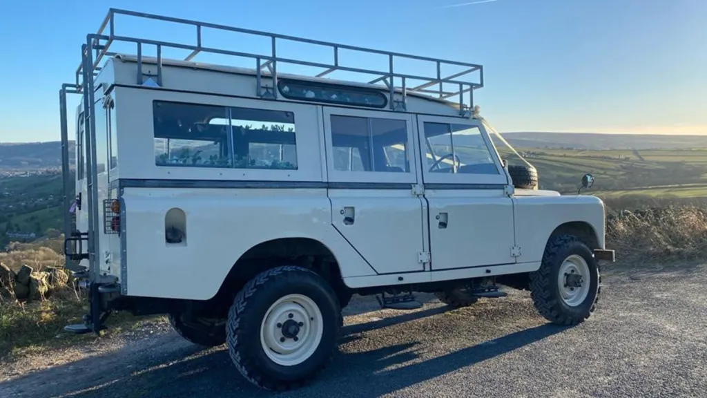 Right side view of Landrover showing the metal roof rack and large rear windows