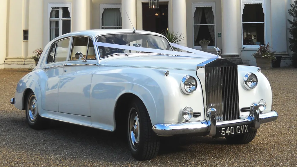 Right Front View of White Classic Rolls-Royce Silver Cloud Mk1 with single headlights and white wedding ribbon decoration