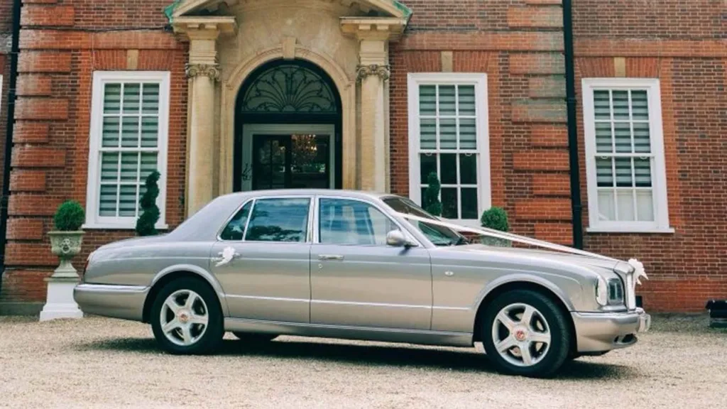 Side view of Bentley Arnage dressed with white ribbons accross the bonnet and bows on rear door handle