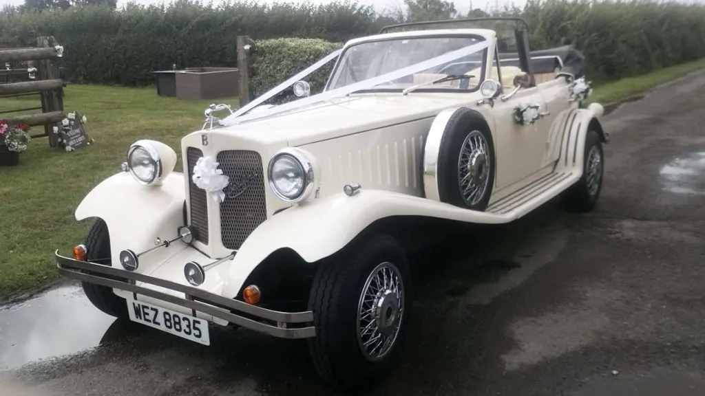 Front side view of vintage beauford in Ivory with roof down decorated with White ribbons and white bow on its front grill