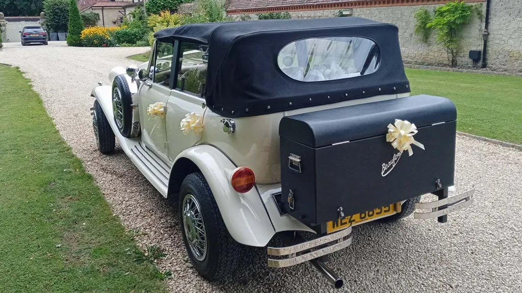 Rear view of Vintage Beauford in Ivory with Convertible Black roof up and Picnic Trunk at the rear