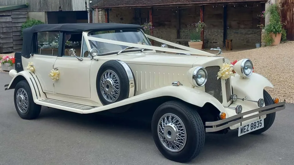 Front right view of Ivory Beauford with Black soft top roof up and white ribbons accross th front bonet
