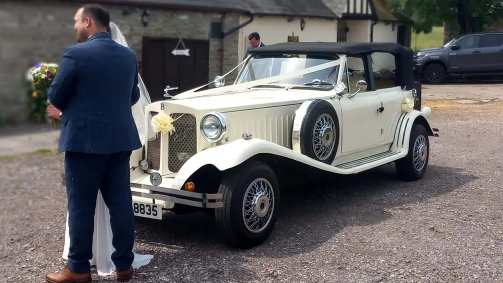Bride and Groom standing in front of an Ivory Beauford with Black Roof up