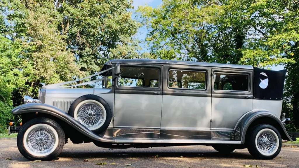 left side view of vintage Limousine with black soft top roof up