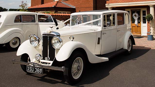 White vintage Car in front of wedding venue