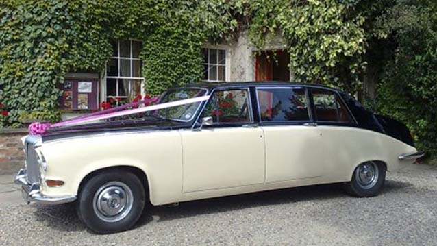 Left Side view of ivory Daimler with Black roof decorated with Light pink Wedding ribbons