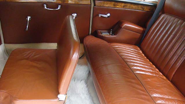 Inside rear cabin casual seat unfolded showing the extra seating space. Tan Leather colour seats and white carpet