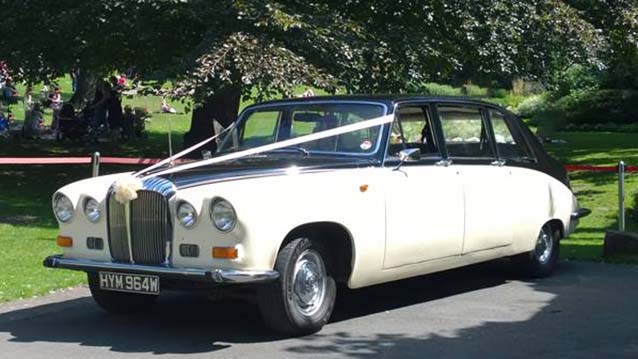 Side view of Classic Ivory Daimler Limousine with Black Roof dressed with pale pink ribbons