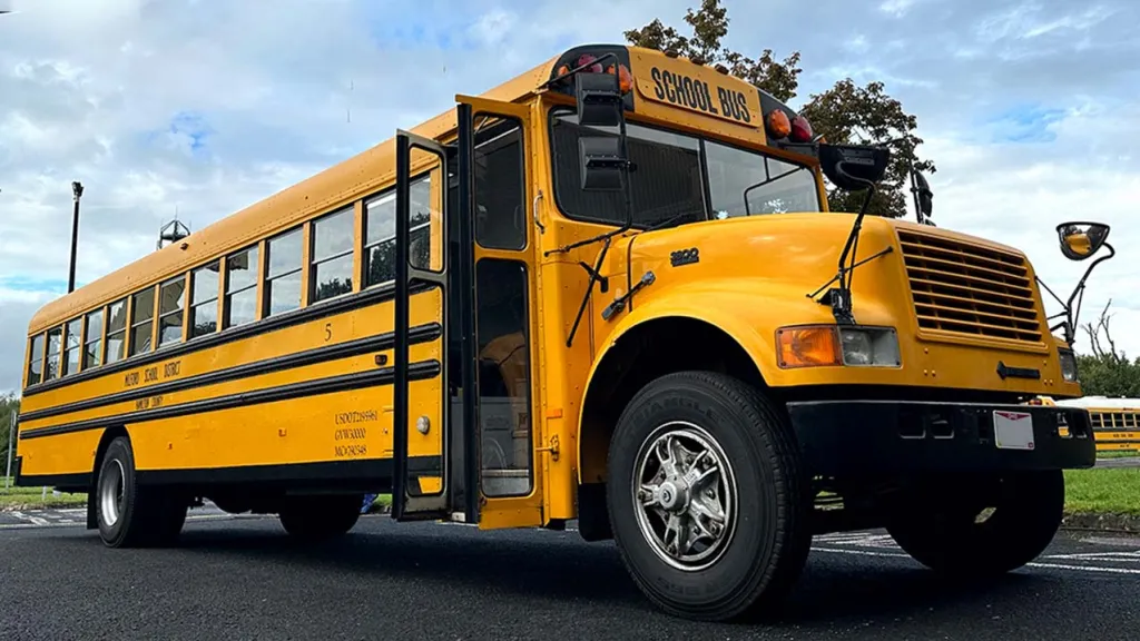 Side view of American Yeallow school bus with front double door open