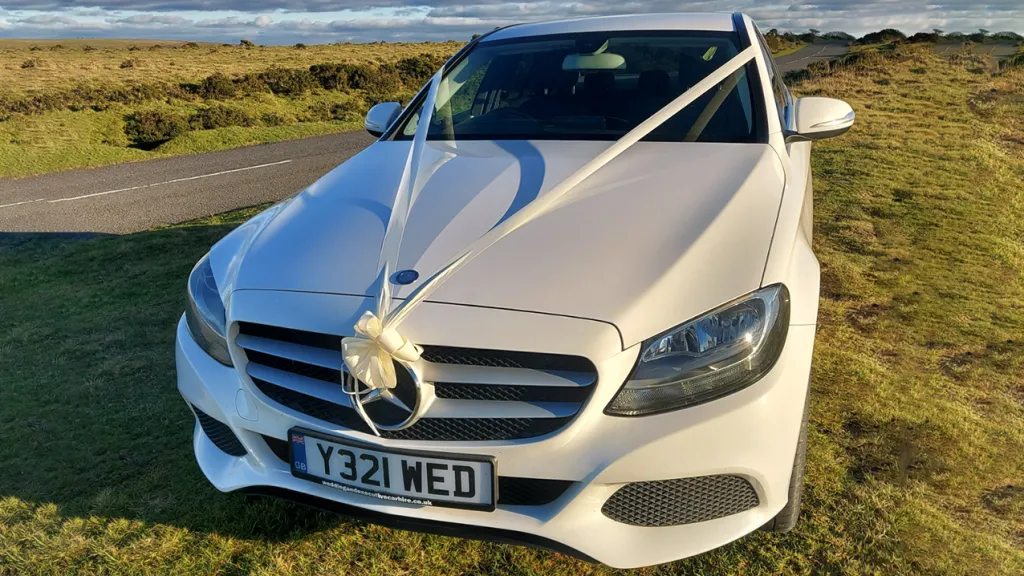 Front view of White Mercedes decorated with ivory Ribbons and Bow on front grill