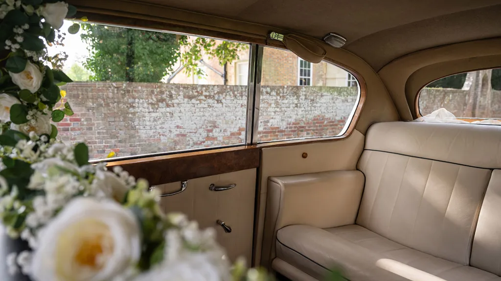 View of cream leather interior of Austin Princess Limousine with neutral white silk flower decoration
