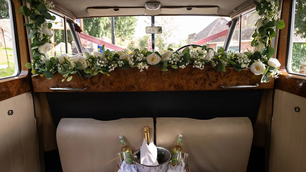 Interior photo showing the wooden dash and wedding foliae decoration inside the vehicle