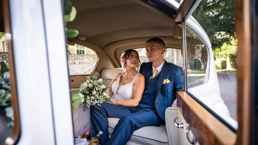 Bride and Groom seating inside the vehicle