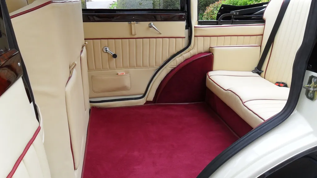 Rear Interior Cream Leather bench seats and Burgundy Carpet both extra seats are folded up showing plenty of space