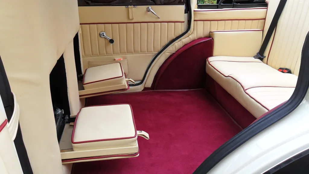 Interior of Vintage Branford with Cream Leather seats and Burgundy Carpet both casual extra seats for fourth and fifth passengers are lowered and facing the rear bench seat