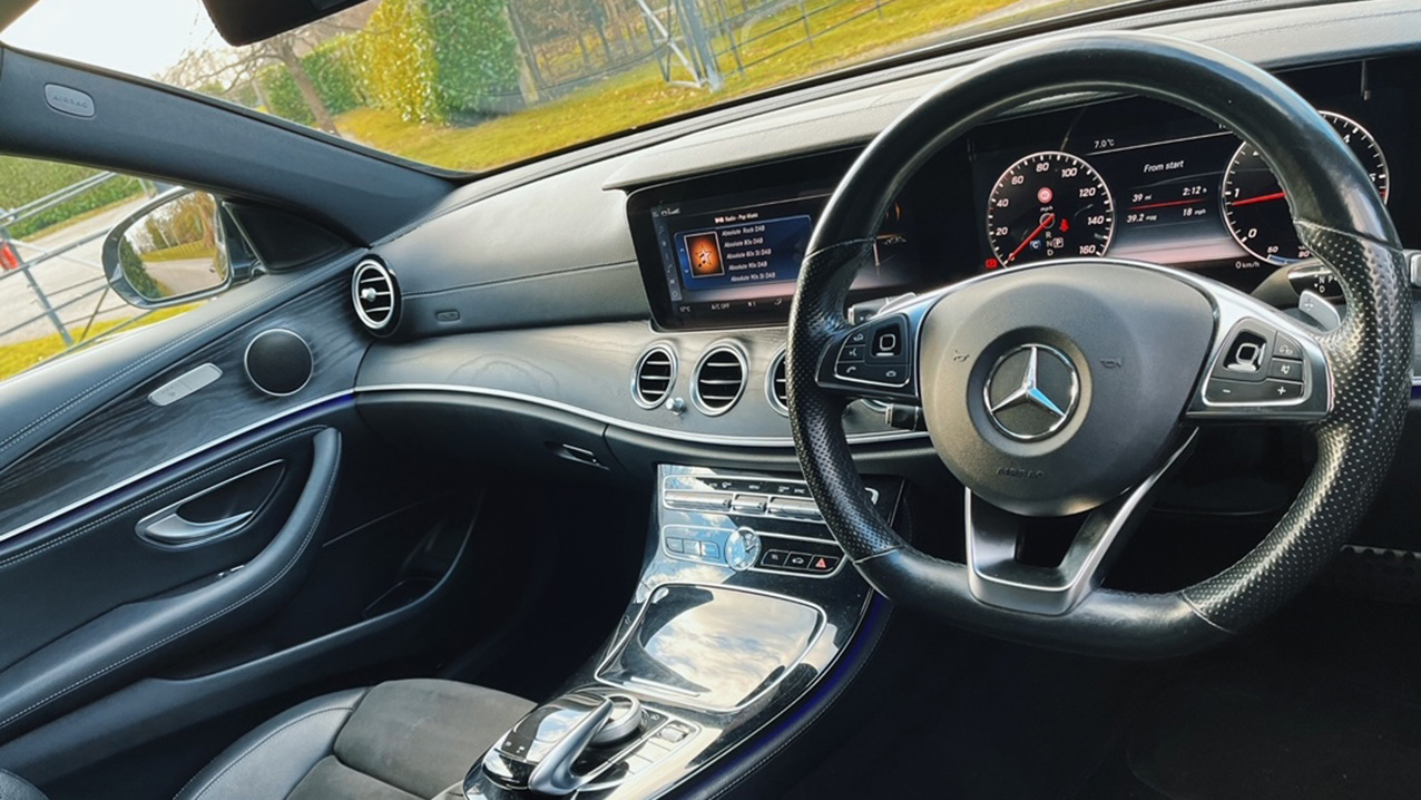 inside Front view of Dashboard and black leather passenger seat in Mercedes E-class