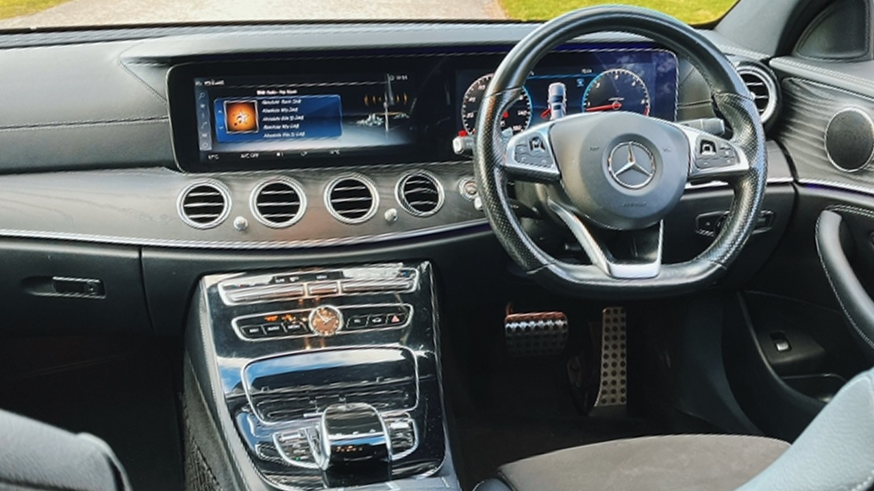 Full inside front view of driver dashboard and steering wheel in Mercedes e-class