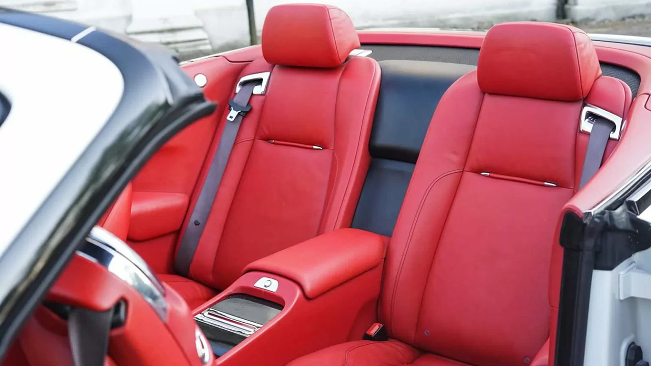 Interior Rear seating in a Rolls-Royce Dawn. Deep Burgundy Leather seats