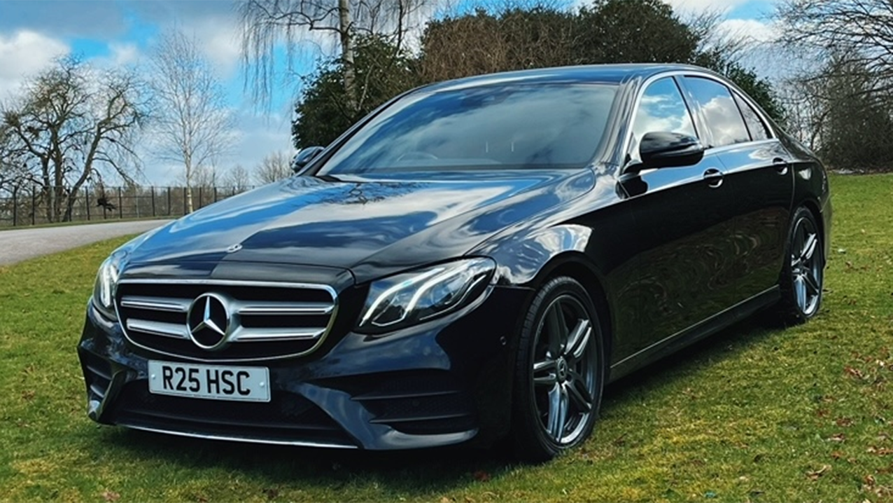 Left front View of Black Mercedes in a green grass field