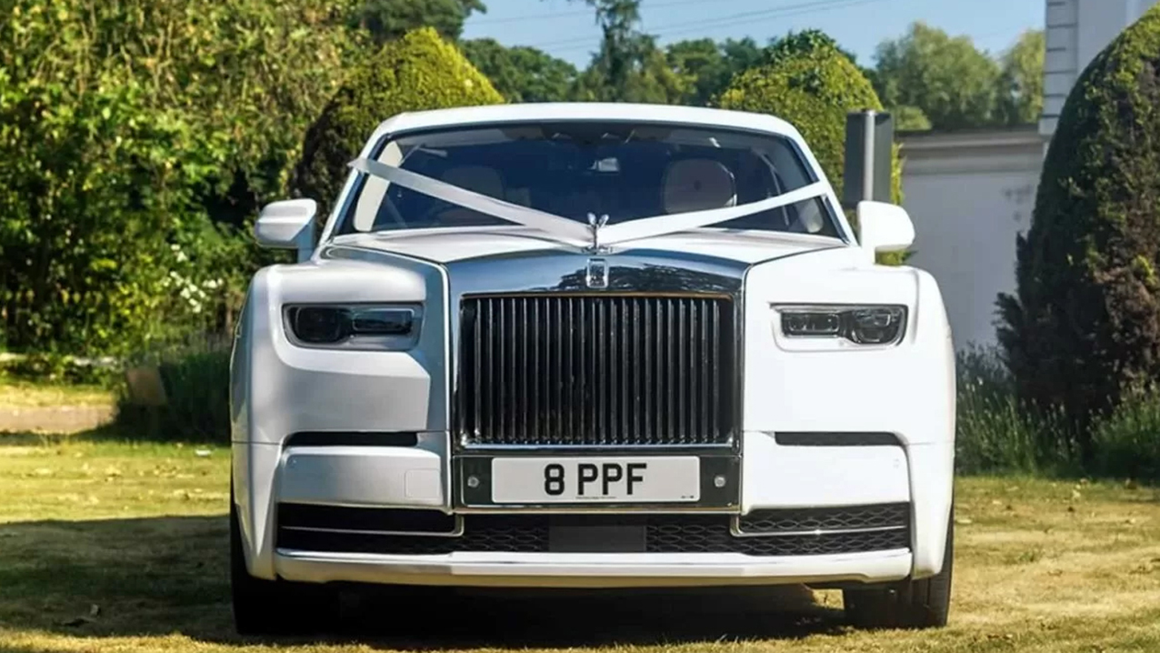Full front view of white rolls-royce Phantom 8, Large iconic Rolls-Royce Chrome Grill with Spirit of ectasy on top.