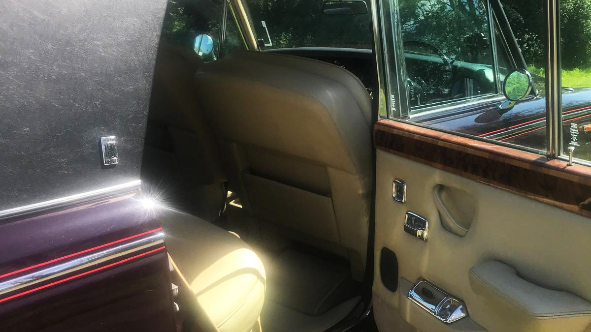 Cream interior rear seats of Rolls-Royce Silver Shadow, matching cream leather door cards and wood accross top of the doors