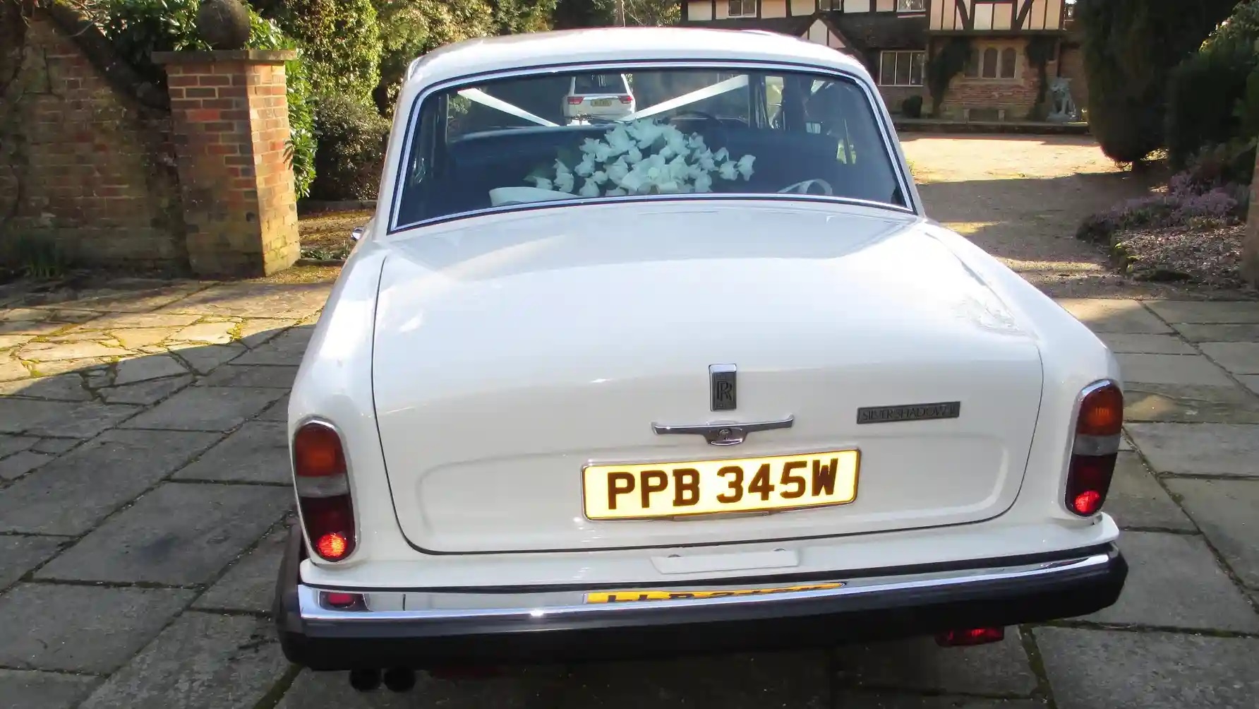 Rear view of Classic Rolls-Royce Silver shdaow showing the posy of wedding flowers on the parcel shelf through the rear window