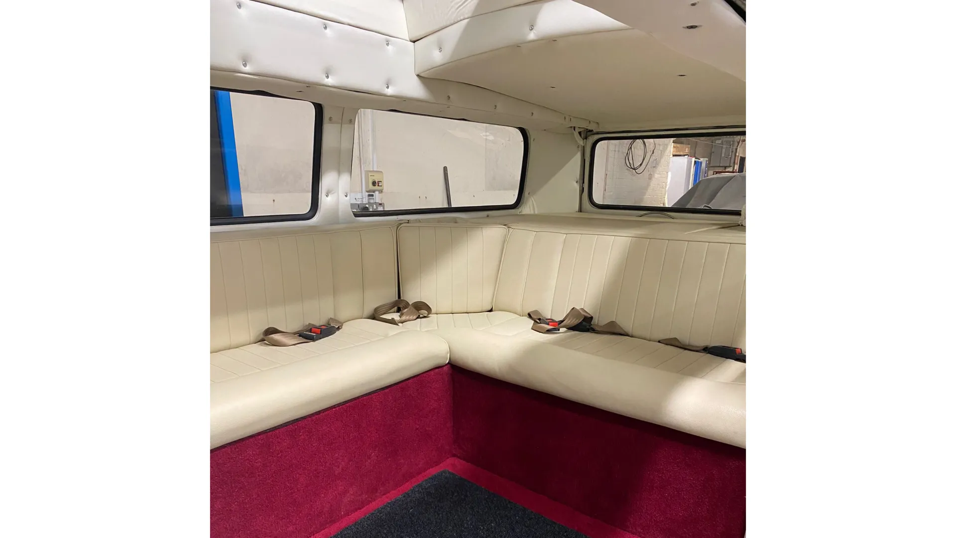 interior of classic VW Campervan showing L-Shape cream bench seat and Burgundy bottom bench