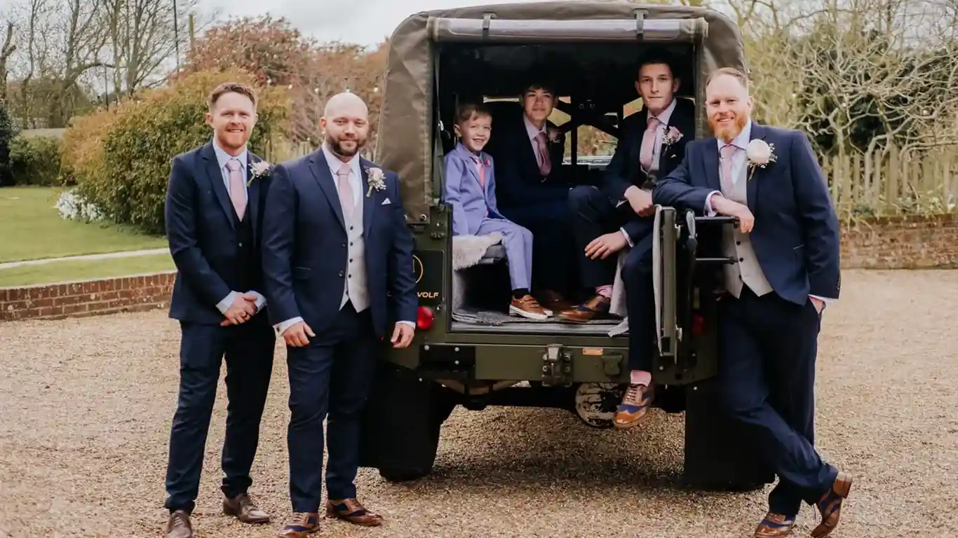 Groomsmen standing by the Landrover
