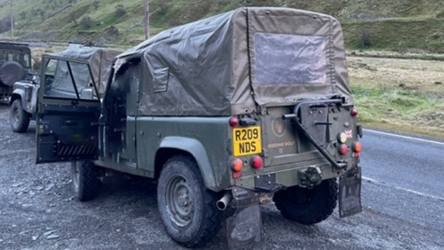 Rear side view of Landrover Defender showing the green canvas over the rear seating area