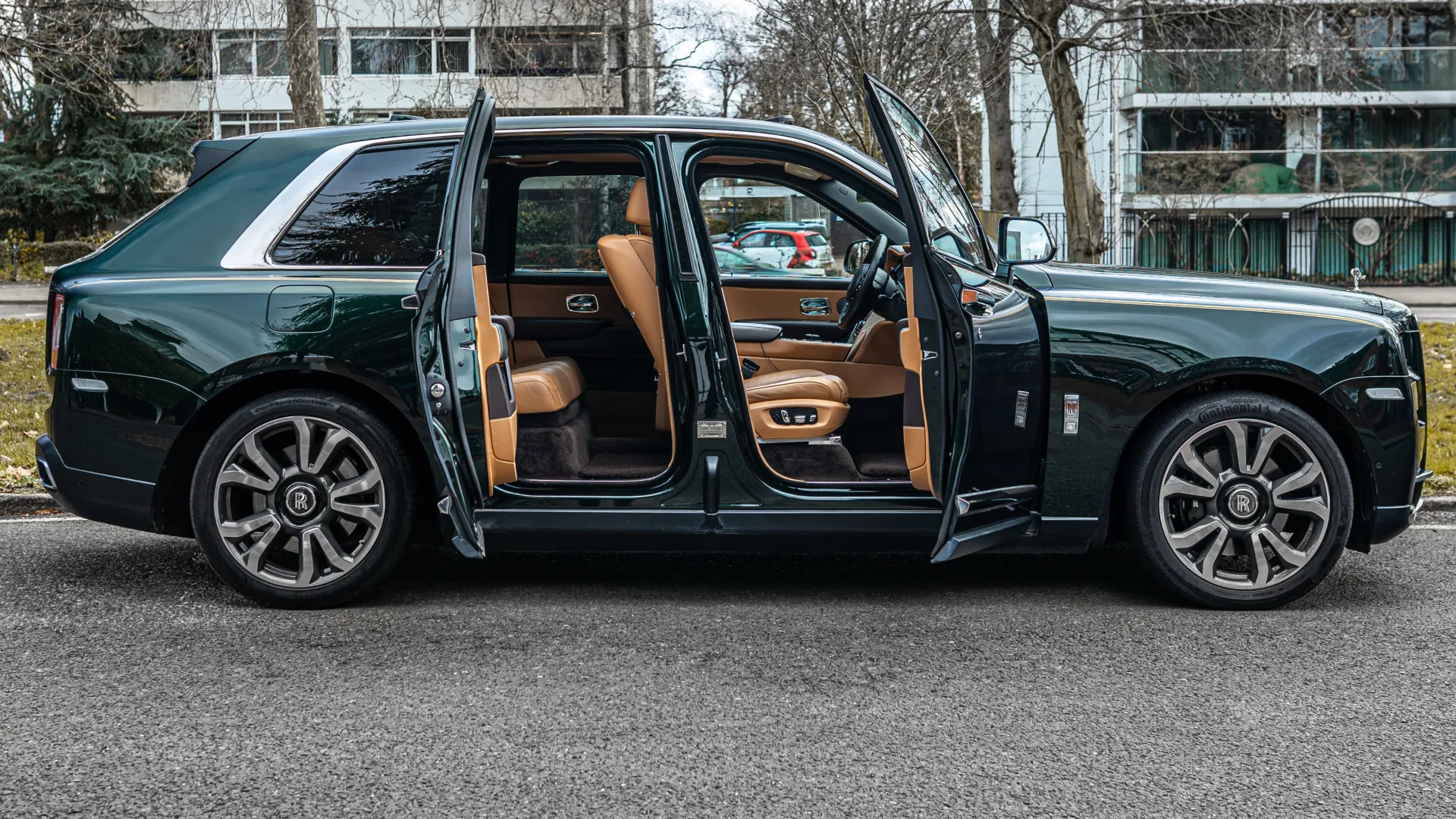 Side view of Modern Rolls-Royce cullinan with both doors open showing tan leather interior