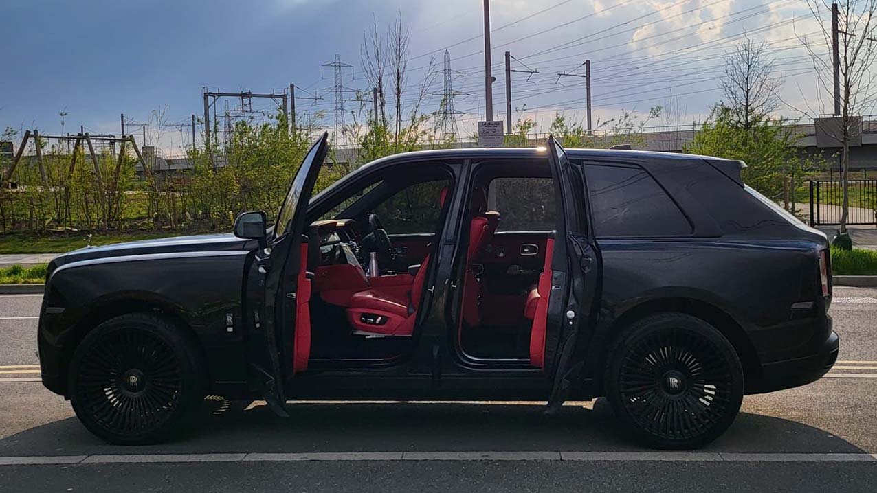 Side view of Modern rolls-royce Cullinan with both doors open showing Burgundy leather interior
