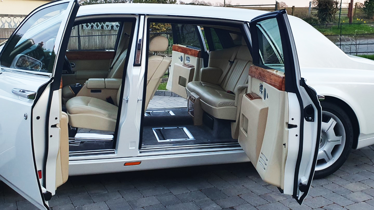 Side view of White rolls-Royce Phantom with Doors open showing the Cream Leather interior