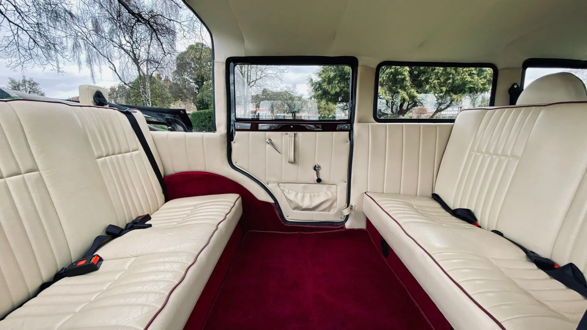 interior of the vintage style Bramwith shwoing cream leather seats facing each others and burgundy carpet