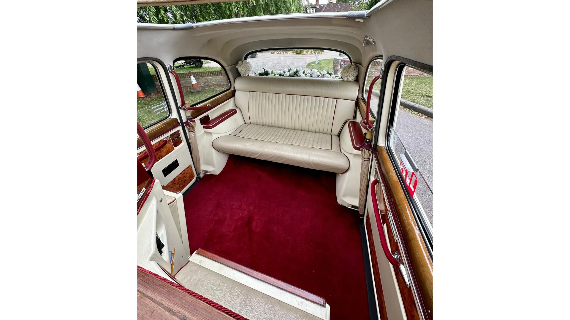 interior of classic taxi cab with cream interior and burgundy carpet