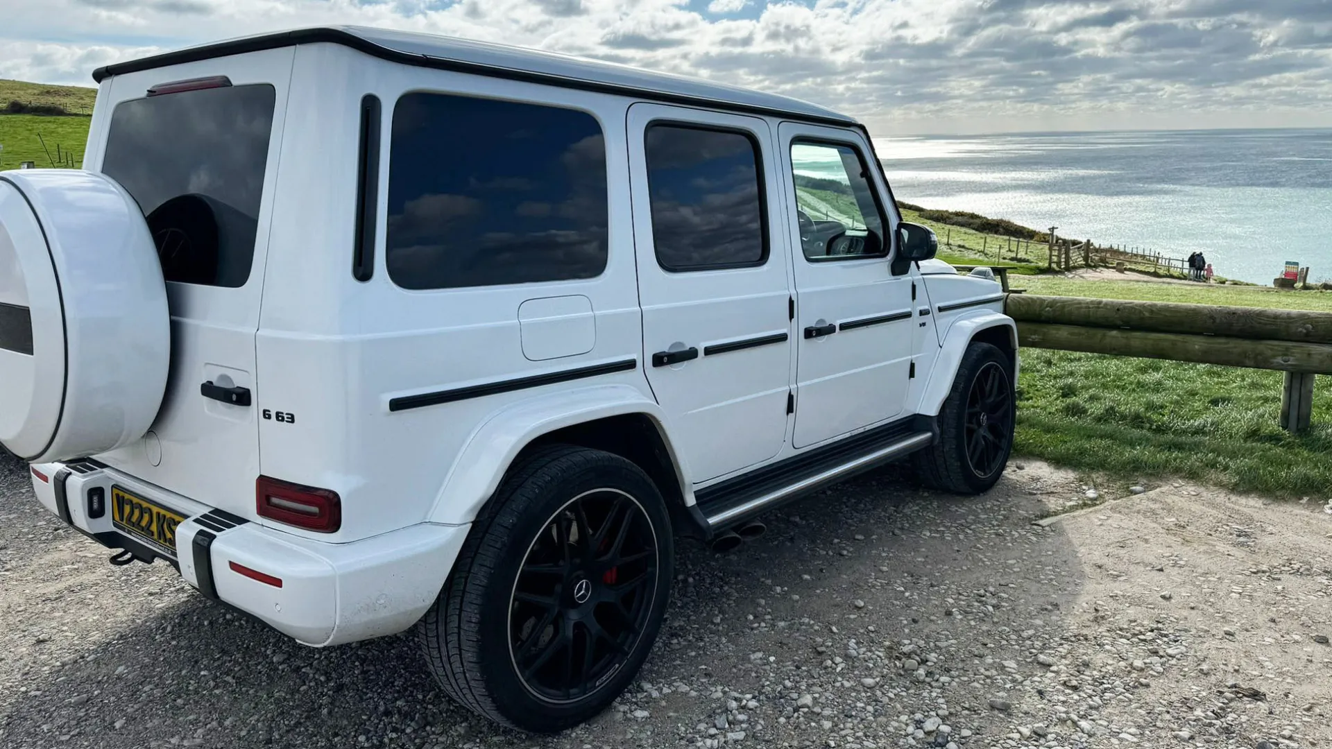 Rear view of Mercedes G-Wagon with seaside in Background, spare wheel mounted on the rear boot.