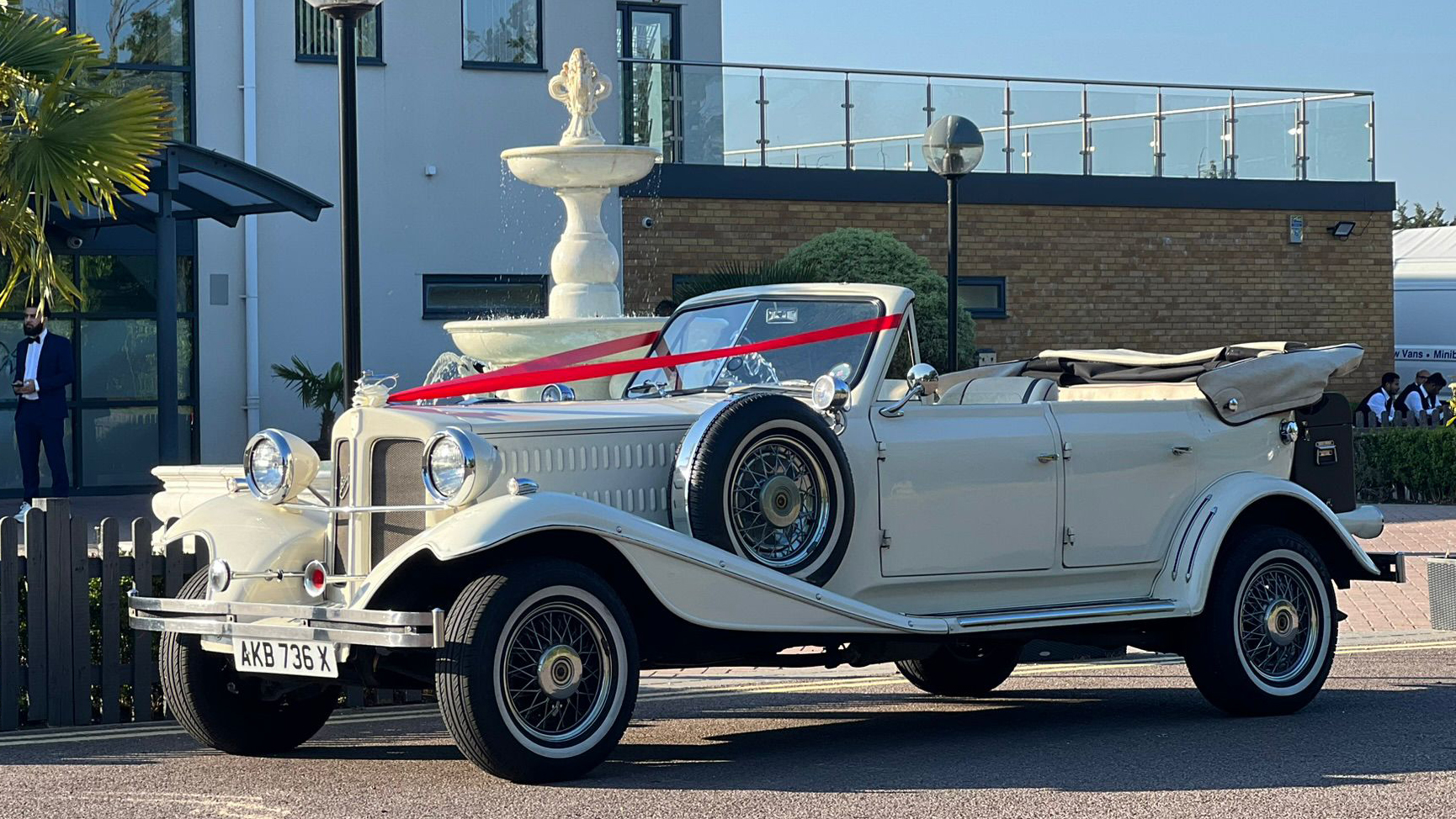 Ivory Convertible Beauford decorated with traditional wedding ribbons accross its bonnet.
