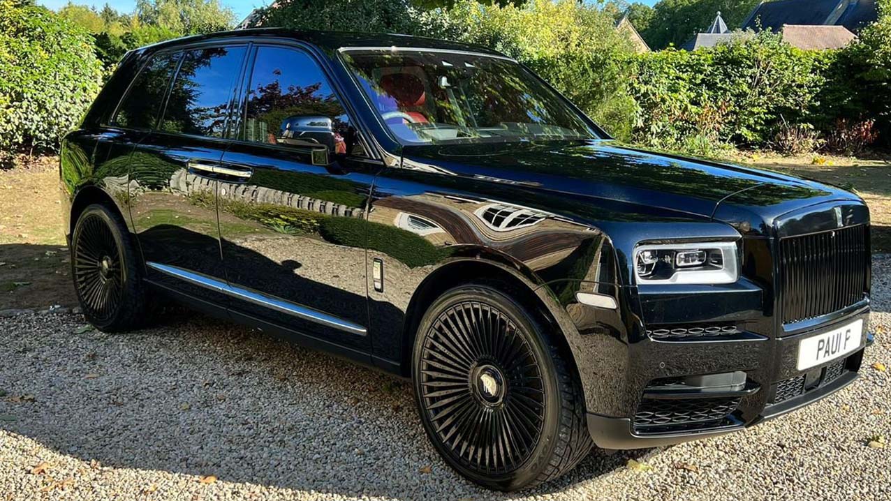 Front Side view of Rolls-Royce Cullinan in Black with Green Forest in the background