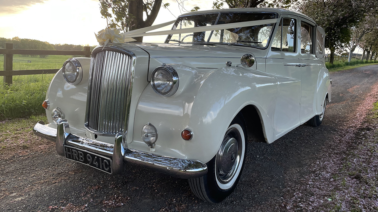 Convertible Classic austin Princess dressed with White Ribbons across the front bonnet.