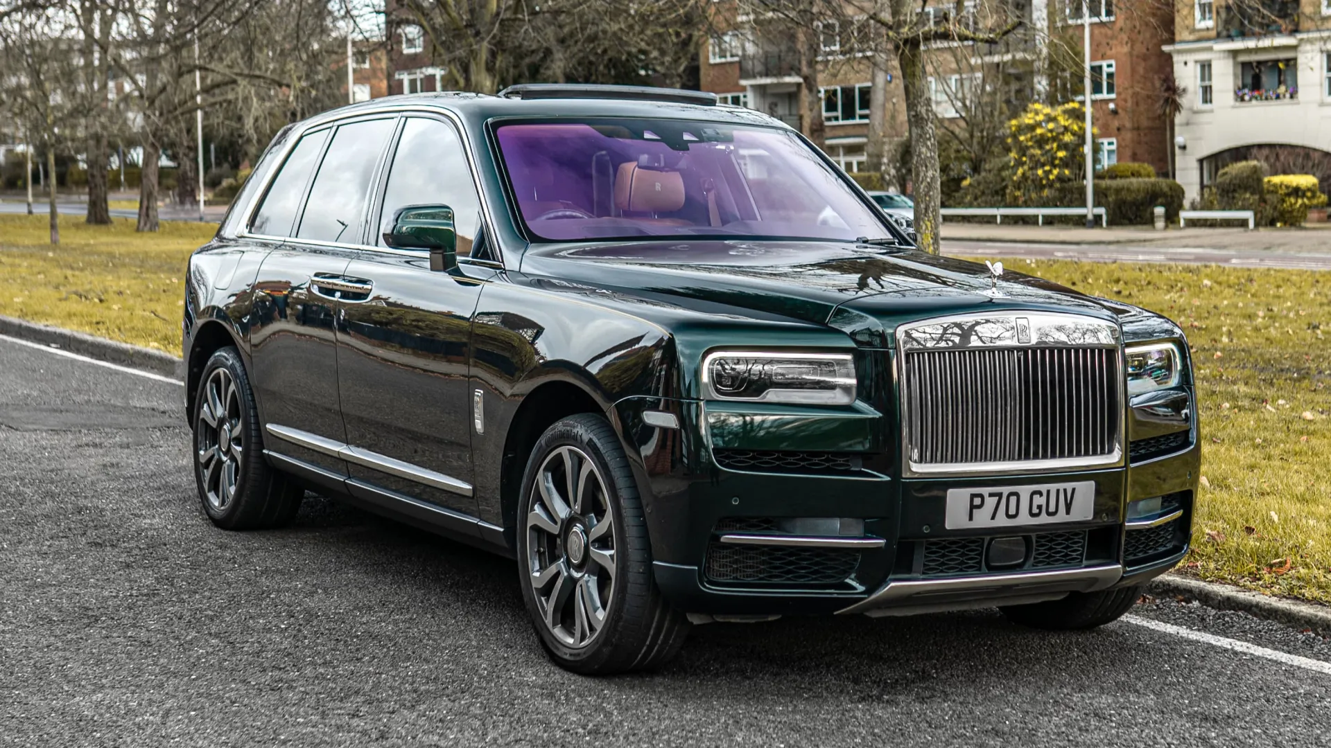 Dark Green Rolls-Royce cullinan right front view sitting in the street of london