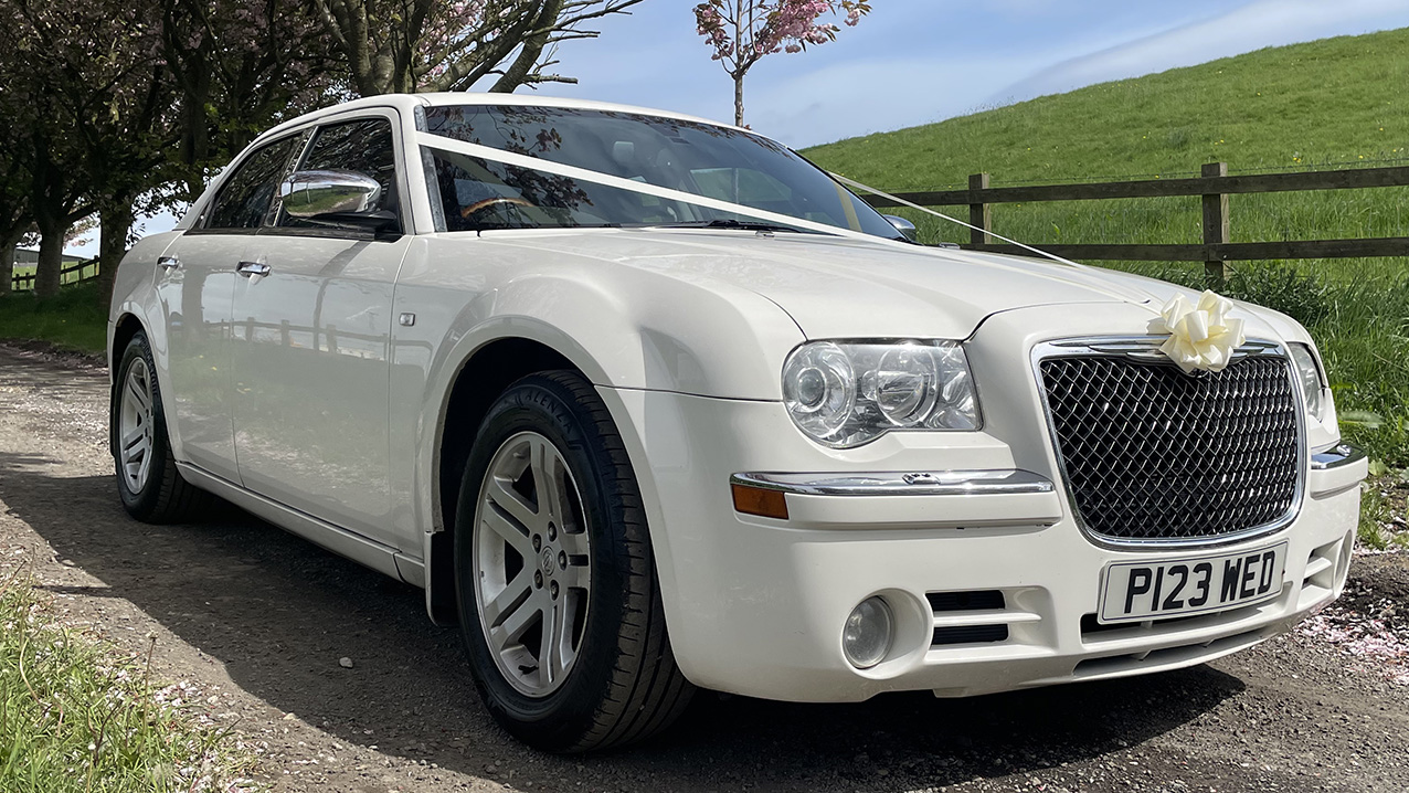 Front view White Chrysler 300c Saloon with White ribbons across the front bonnet