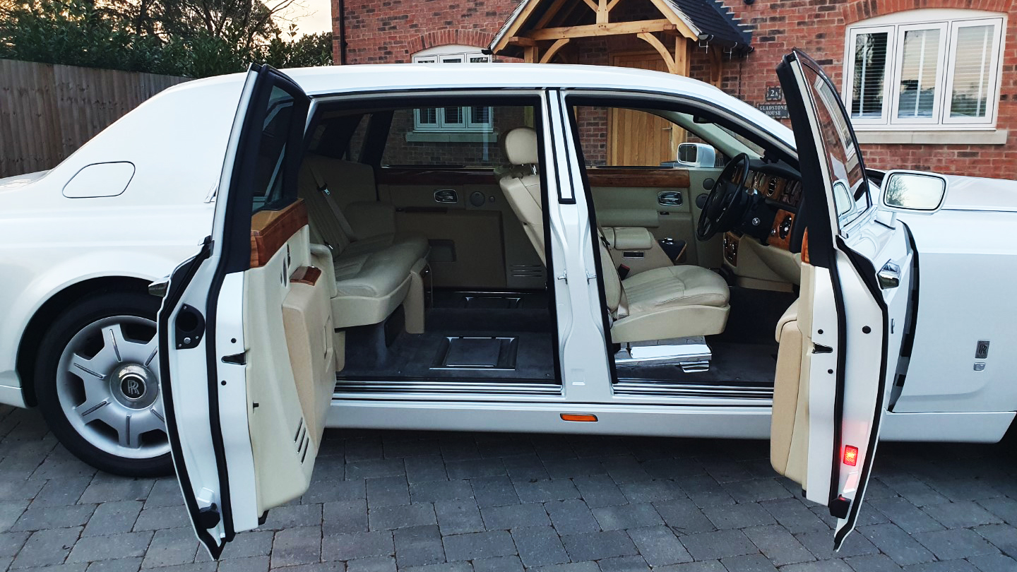 Side view of White rolls-Royce Phantom with Doors open showing the Cream Leather interior