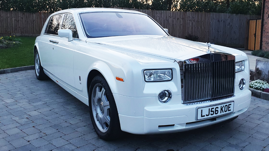 Front side view of White Modern Rolls-Royce Phantom showing large iconic Chrome Rolls-Royce Grill